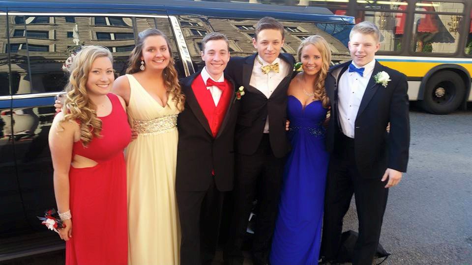 A group of people in formal wear posing for the camera.